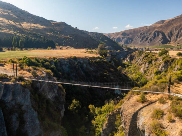 Cyclist riding across the bridge connecting the Arrow River Bridges Trail